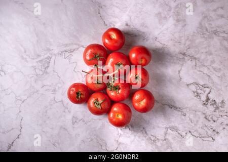 Set of wet tomatoes on a marble table. Stock Photo