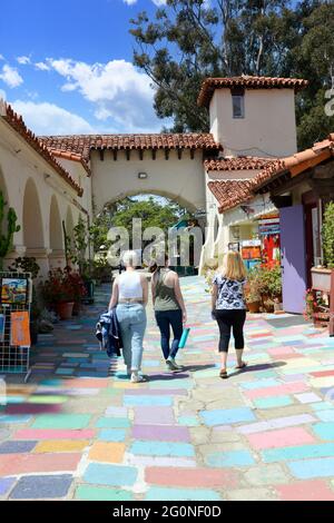 People walking on the colored floor pavers discovering the arts and crafts on sale by local artists in the Spanish Village Art Center, San Diego, CA Stock Photo