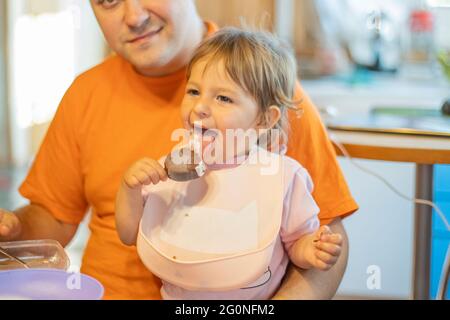 baby try ice cream first time. toddler lick ice cream with happy emotion. tasty sweet food no diet day Stock Photo