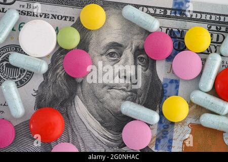 A one hundred dollar bill with medical pills on it. Close up. Stock Photo