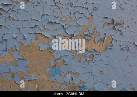 shabby peeling blue paint over plaster wall texture and background. Stock Photo