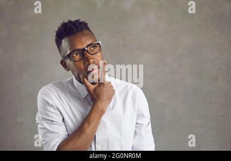 Young African American business man in eyeglasses deep in thought about something Stock Photo