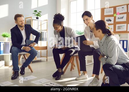 Happy young people working on project, analyzing data and having fun in group meeting Stock Photo