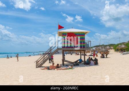 Lifeguard post tower with tourists sunbathing on Cancun Dolphin Beach (Playa Delfin) by the Caribbean Sea, Cancun, Mexico. Stock Photo