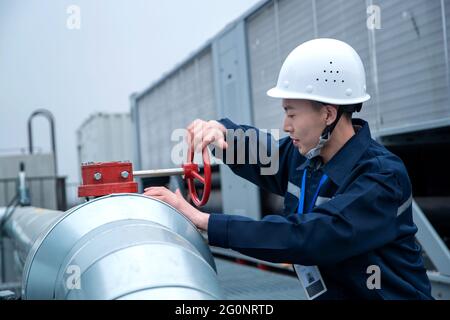 Technical personnel in the factory inspection pipeline switch Stock Photo