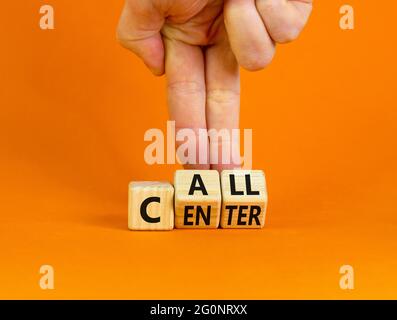Call center symbol. Businessman turns wooden cubes with words 'Call center'. Beautiful orange background. Call center and business concept. Copy space Stock Photo
