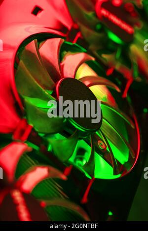 Powerful graphics card with three fans and a futuristic red-green neon backlight. High-tech GPU for gaming and mining of crypto farms Stock Photo