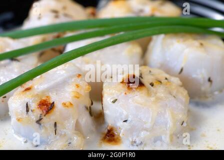 perfectly cooked scallops served with green onion Stock Photo