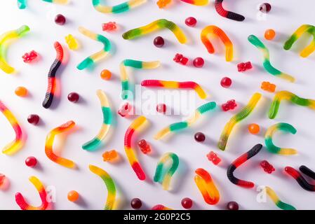 Pattern of colorful gummy bears and worms against white background top view. Delicious Sweets. Stock Photo