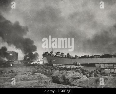 Waterfront at Inchon blazes as Marines pour in from landing craft and an LST pushes up on the shore, all her guns firing in th great amphibious flanking move against the North Koreans, September 15, 1950 Stock Photo