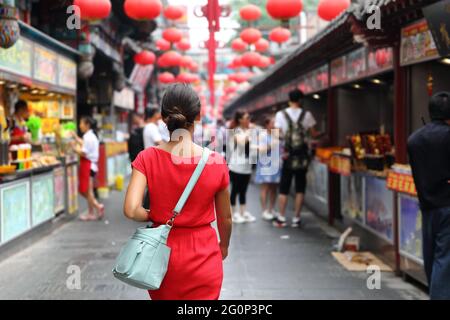 Woman tourist walking in chinatown on china travel. Asian girl on Wangfujing food street during Asia summer vacation. Traditional Beijing snacks being Stock Photo