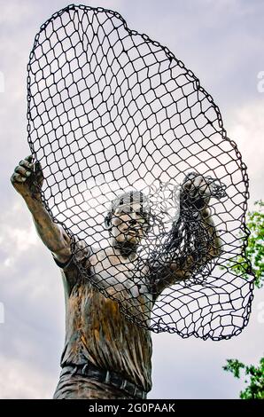 The Golden Fisherman “Casting His Net Into Eternity” statue stands in front of the Maritime and Seafood Industry Museum in Biloxi, Mississippi. Stock Photo