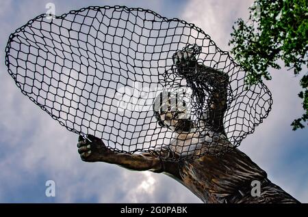 The Golden Fisherman “Casting His Net Into Eternity” statue stands in front of the Maritime and Seafood Industry Museum in Biloxi, Mississippi. Stock Photo