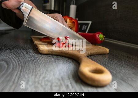 A person cutting a pepper to prepare it for cooking Stock Photo