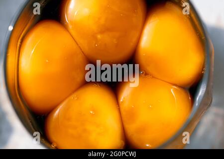Bright egg yolks in a Japanese marinade in a glass.  Stock Photo