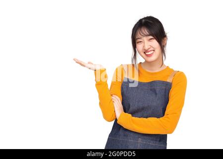 Young Asian woman cook or baker presenting something with empty space isolated on white background, Chef bakery female concept Stock Photo