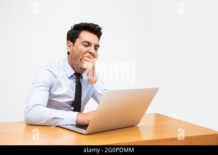 Tired businessman exhausted and yawn after hard work and excessive workload isolated on white background Stock Photo