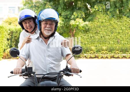 Senior asian couple riding motorcycle, Happy active old age and lifestyle concept Stock Photo