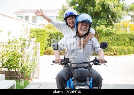 Senior asian couple riding motorcycle, Happy active old age and lifestyle concept Stock Photo