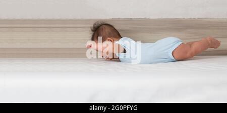 Baby boy lift up the chest and sometimes the legs up with arms lifted sideways, Action of infant and toddler skills concept. Three month old Stock Photo