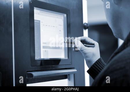 The man works on the machine monitor Stock Photo