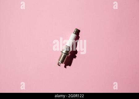 Spark plug. Car candle lies against a pink background. Auto engine electrician. Flay lay. Copy space Stock Photo