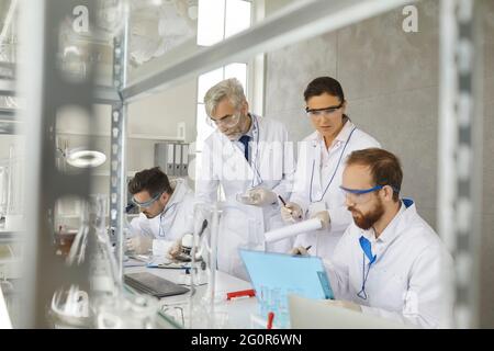 Research scientists team working using computer and medical equipment at lab Stock Photo