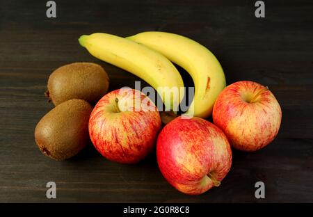 Assorted Fresh Ripe Tasty Fruits on Dark Brown Wooden Backdrop for the Concept of WELLNESS Stock Photo