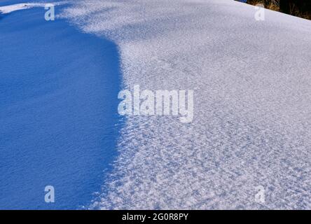 Texture of a snow surface with areas of shadow and light Stock Photo