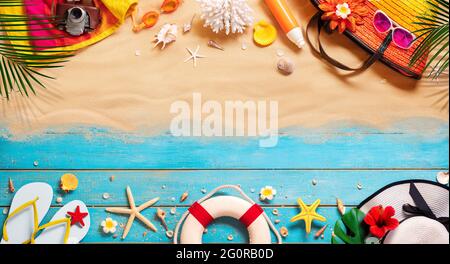Beach Accessories On Tropical Sand And Wooden Table Stock Photo