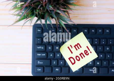 Text on yellow stick note on top of black keyboard Stock Photo