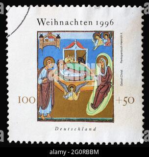 A Christmas stamp printed in Germany shows Birth of Jesus Christ, Illustration from Henry II's 'Book of Pericopes', circa 1996 Stock Photo