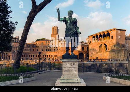 Rome, Italy.   Statue of the Emperor Trajan with Trajan's Forum behind.  The forum dates from the second century AD.   The tower, centre, is the 13th Stock Photo