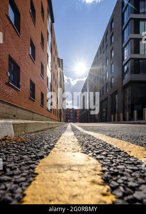 Double yellow lines on deserted street. Parking restrictions sunset with sun shining on tarmac road. Prohibition on car park on carriageway. Stock Photo