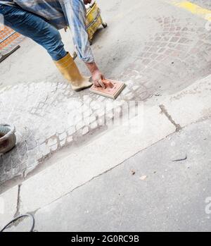 remaking of the road surface, manual laying of porphyry cubes in the city Stock Photo