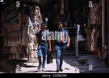 Baghdad, Iraq. 02nd June, 2021. Military members walk in front of military clothing stores. Credit: Ameer Al Mohammedaw/dpa/Alamy Live News Stock Photo