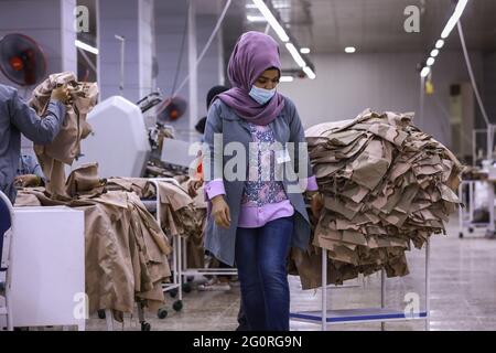 Baghdad, Iraq. 02nd June, 2021. A garment worker moves fabrics during the production of the Iraqi Armed Forces members' clothing. The factory reopened in 2019 after it was damaged during the Battle of Baghdad in 2003. Credit: Ameer Al Mohammedaw/dpa/Alamy Live News Stock Photo