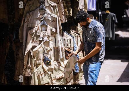 Baghdad, Iraq. 02nd June, 2021. A military member checks a military outfit at a military clothing store. Credit: Ameer Al Mohammedaw/dpa/Alamy Live News Stock Photo