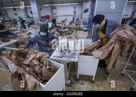 Baghdad, Iraq. 02nd June, 2021. Garment workers work on sewing machines as they produce clothing for the Iraqi Armed Forces members. The factory reopened in 2019 after it was damaged during the Battle of Baghdad in 2003. Credit: Ameer Al Mohammedaw/dpa/Alamy Live News Stock Photo