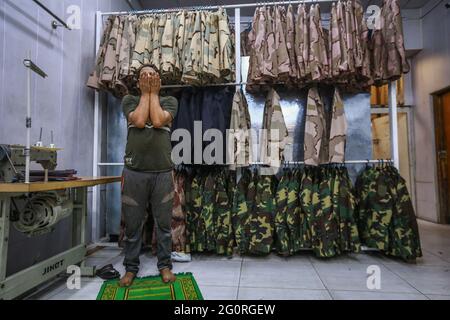 Baghdad, Iraq. 02nd June, 2021. A garment prays at a military sewing factory. The factory reopened in 2019 after it was damaged during the Battle of Baghdad in 2003. Credit: Ameer Al Mohammedaw/dpa/Alamy Live News Stock Photo