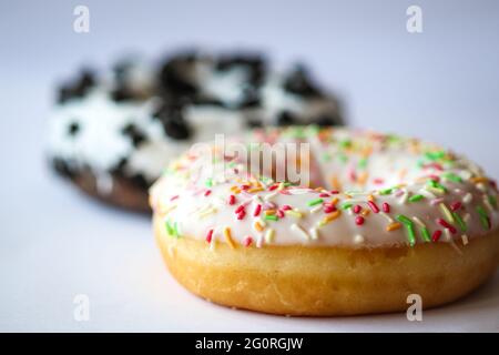 Close-up on ring donut with white glaze and colourful hundreds and thousands Stock Photo