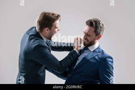 two angry businessmen punching in fight and arguing having struggle for leadership, confrontation. Stock Photo