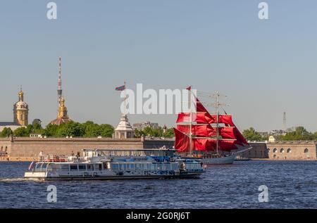 pleasure boat passing red-sails ship on neva river near peter and paul fortress, st petersburg, russia Stock Photo