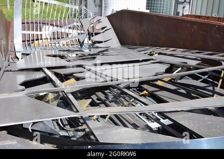 Metal plates as waste collected in a container in a community disposal place. Stock Photo