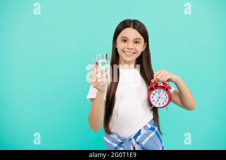 hydration vitality. drinking per day. be hydrated. kid hold glass and clock. child feel thirsty. Stock Photo