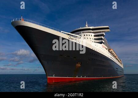 The magnificent Queen Mary 2 ocean liner cruise ship sits on calm seas whilst anchored off Torbay in Devon, UK. Stock Photo