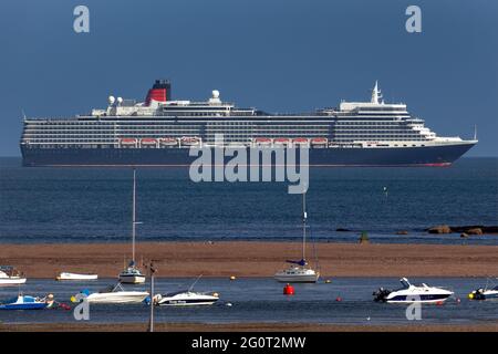 The Queen Elizabeth cruise ship basks in glorious sunshine off the coast of Teignmouth, Devon. Stock Photo