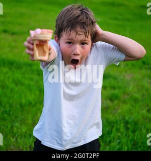 Amazed boy with empty fake ice cream, food problems Stock Photo