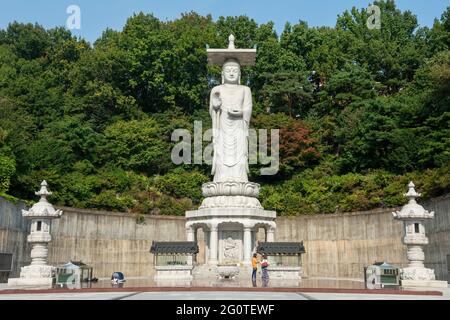 Buddha statue on green trees background in Bongeunsa Temple at Gangnam District in Seoul, South Korea. It is a popular tourist attraction of Asia. Stock Photo