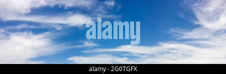 Panorama with blurred small clouds in the blue sky. Stock Photo